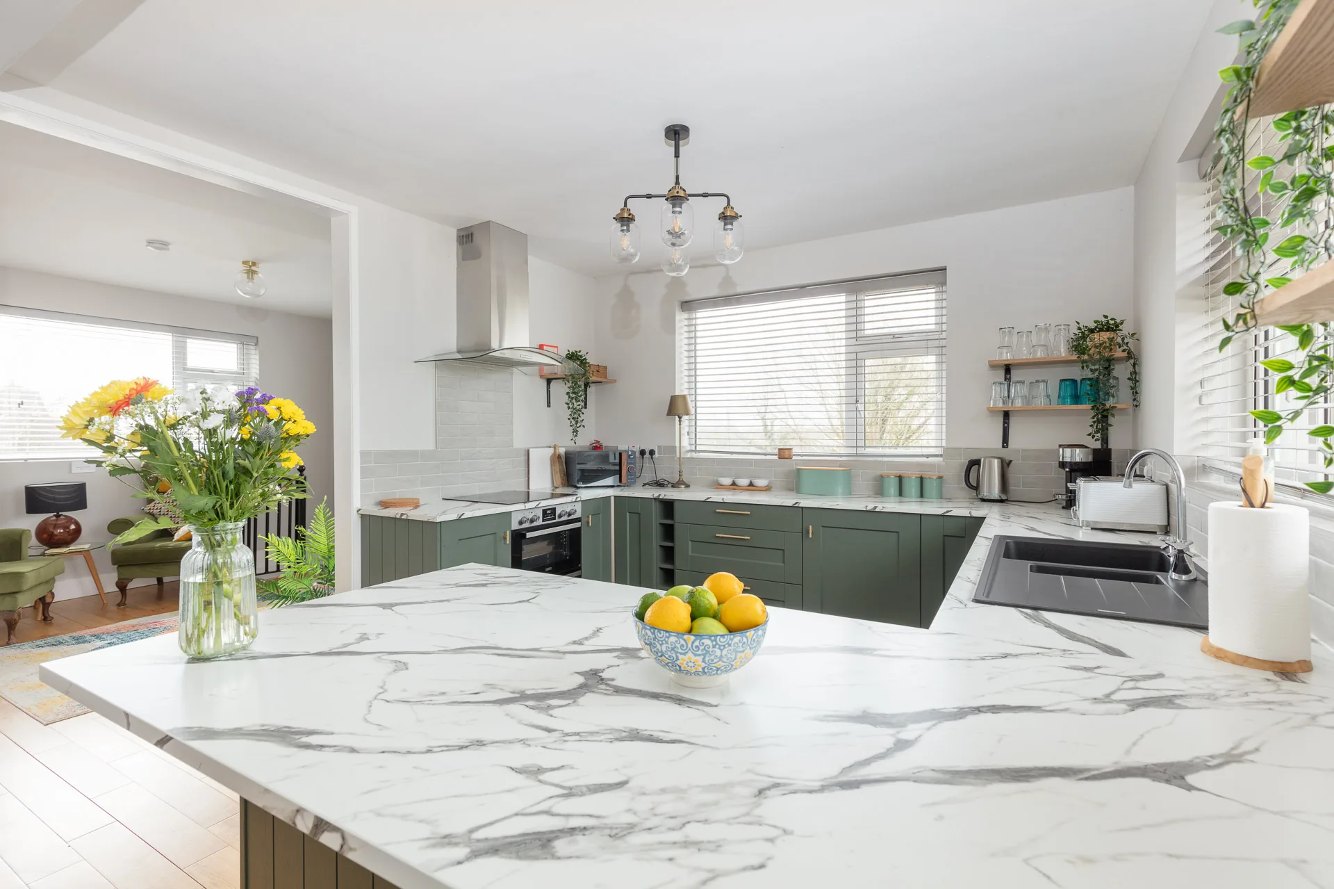 Open-plan green kitchen and dining room at Milltown Cottage